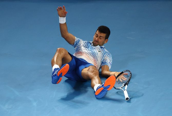 Novak Djokovic slips and falls while hitting a cross-court backhand return in the second set.