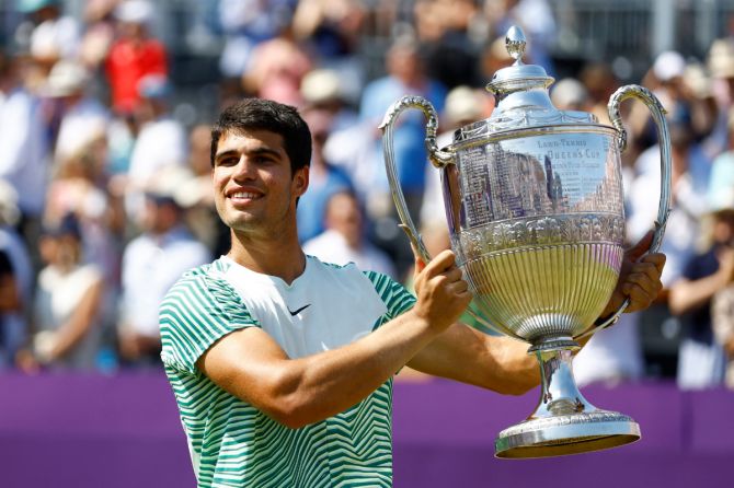 Spain's Carlos Alcaraz celebrates with the trophy after beating Australia's Alex de Minaur to win the Queen's Club Championships in Queen's Club, London, on Sunday