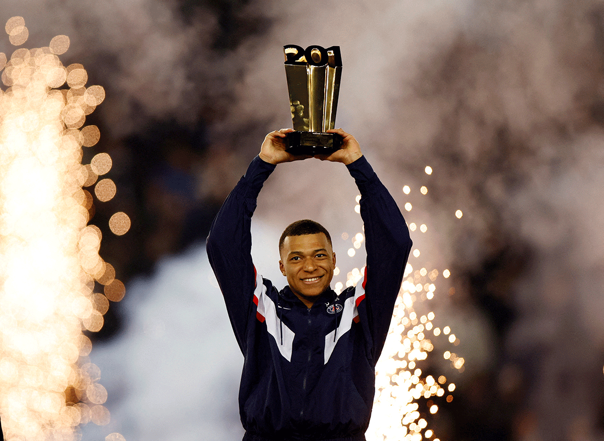 Paris St Germain's Kylian Mbappe celebrates with a trophy during the ceremony after becoming Paris St Germain's all time top goalscorer with 201 goals after the Ligue 1 match against Nantes on Saturday 