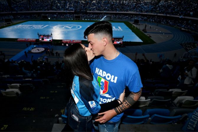 Fans of SSC Napoli kiss during the Serie A match between Udinese Calcio and SSC Napoli at a screening at Stadio Diego Armando Maradona in Naples, Italy.