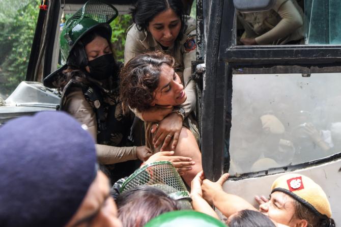 Police personnel detain wrestler Vinesh Phogat during the protest march from Jantar Mantar to New Parliament House against the alleged sexual harassment of women wrestlers by WFI chief Brij Bhushan Sharan Singh, in New Delhi on Sunday