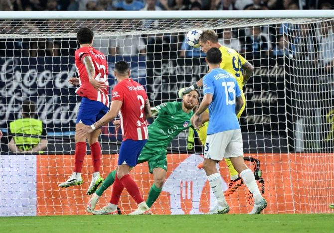 Lazio's goalkeeper Ivan Provedel towers above a host of Atletico Madrid players to head the ball home in the Champions League Group E match at the Stadio Olimpico, in Rome, on Tuesday.