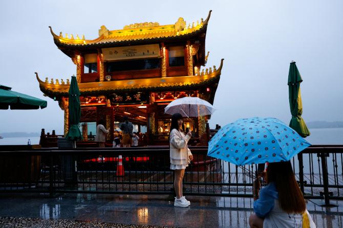 Women pose for photography by West lake ahead of the 2023 Asian Games in Hangzhou.