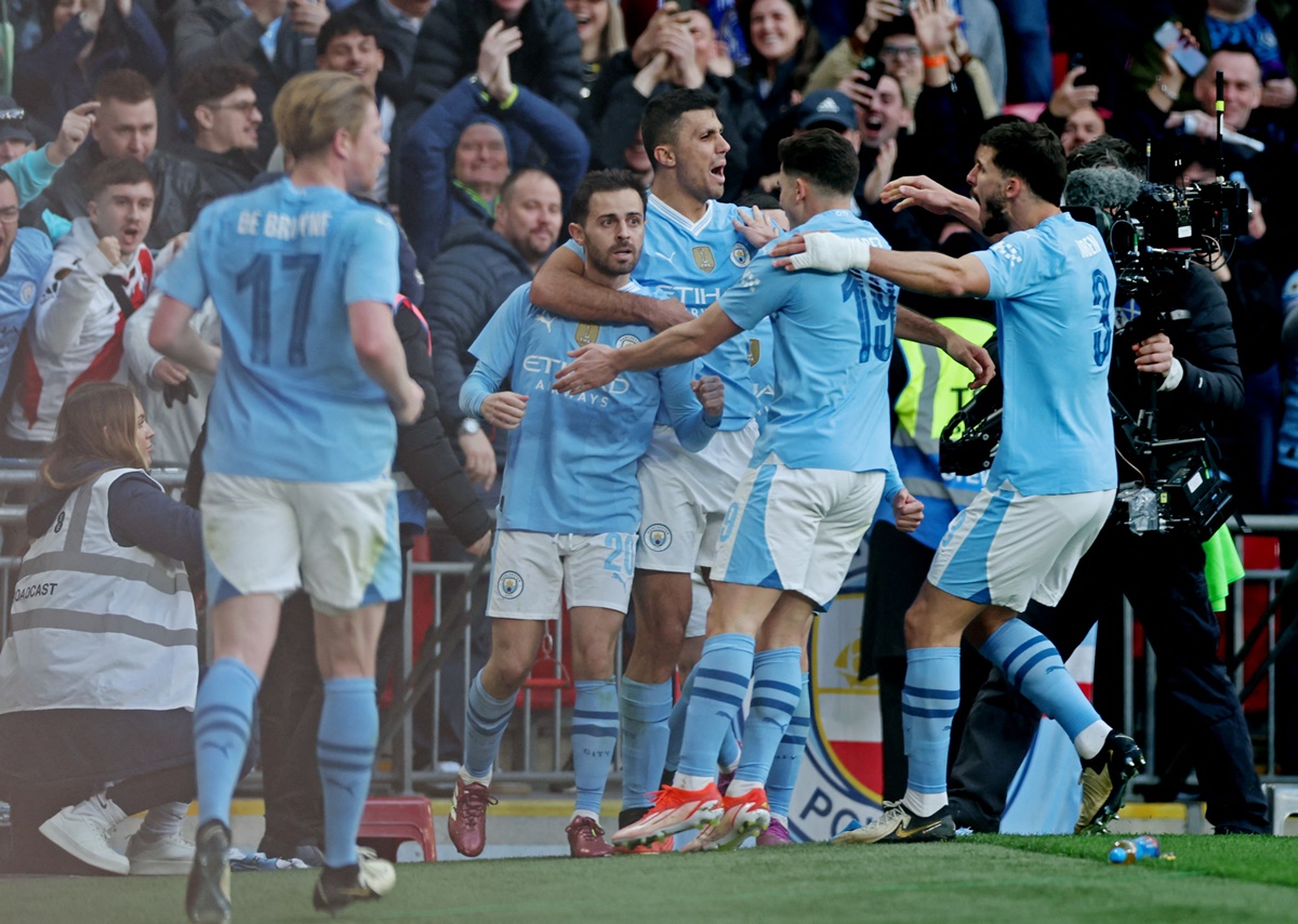 Manchester City players celebrate with match-winner Bernardo Silva after the final whistle is blown.