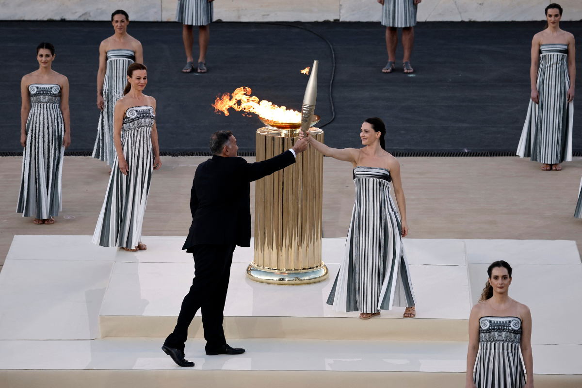 Greek actress Mary Mina, playing the role of High Priestess gives the torch to President of the Hellenic Olympic Committee and member of the International Olympic Committee Spyros Capralos during the Handover Ceremony at Panathenaic Stadium, Athens, Greece, on Friday