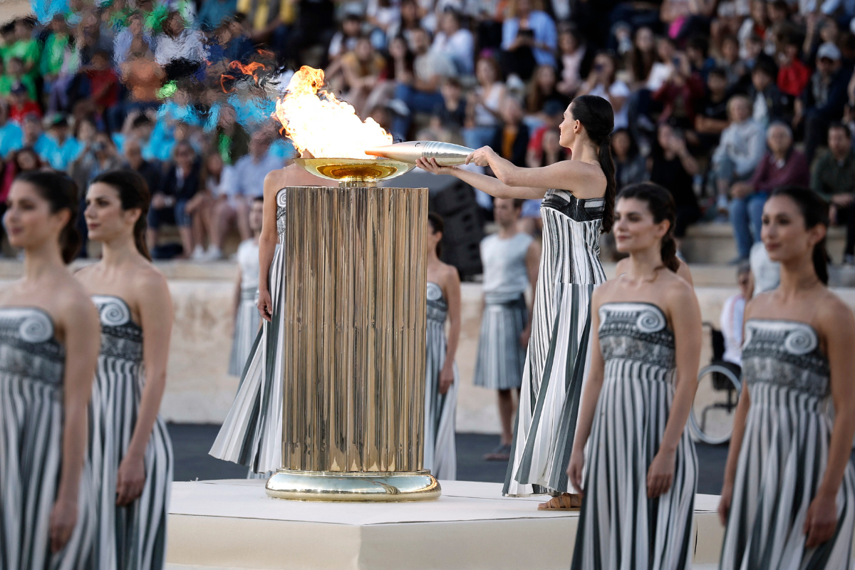 Greek actress Mary Mina, playing the role of High Priestess, holds an olympic torch by the cauldron during the Handover Ceremony