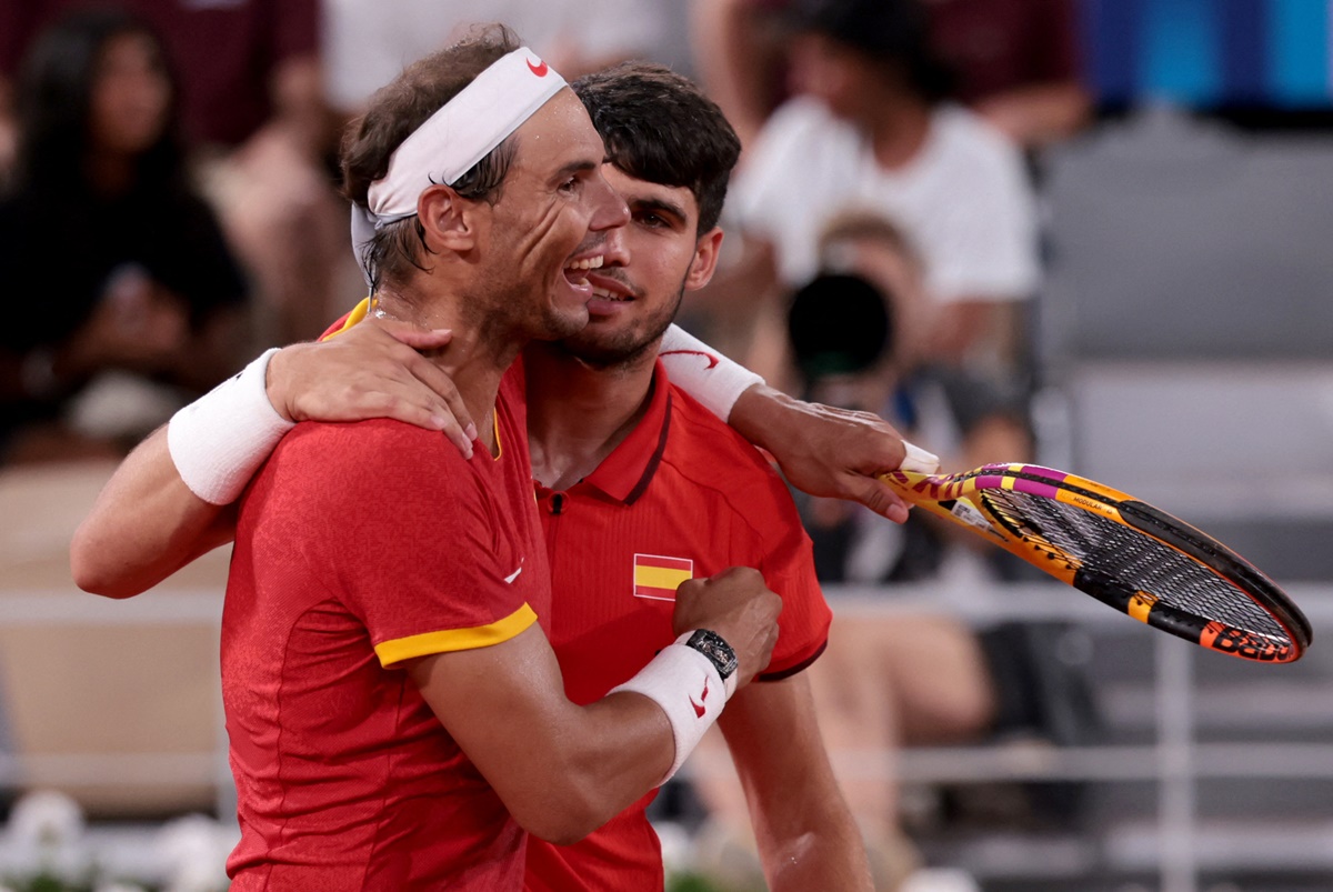 Carlos Alcaraz and Rafael Nadal walk off the court after losing to Austin Krajicek and Rajeev Ram.