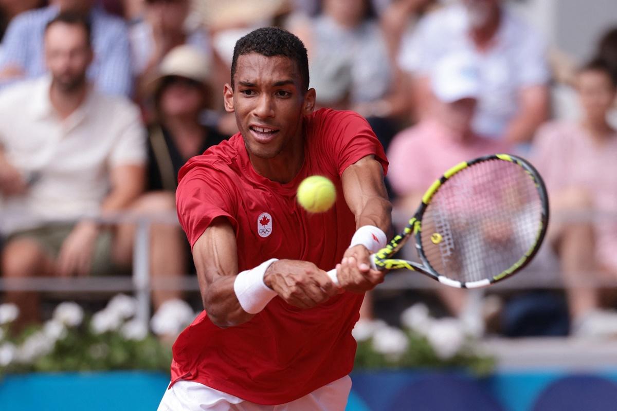 Canada's Felix Auger-Aliassime makes a backhand return to Carlos Alcaraz.