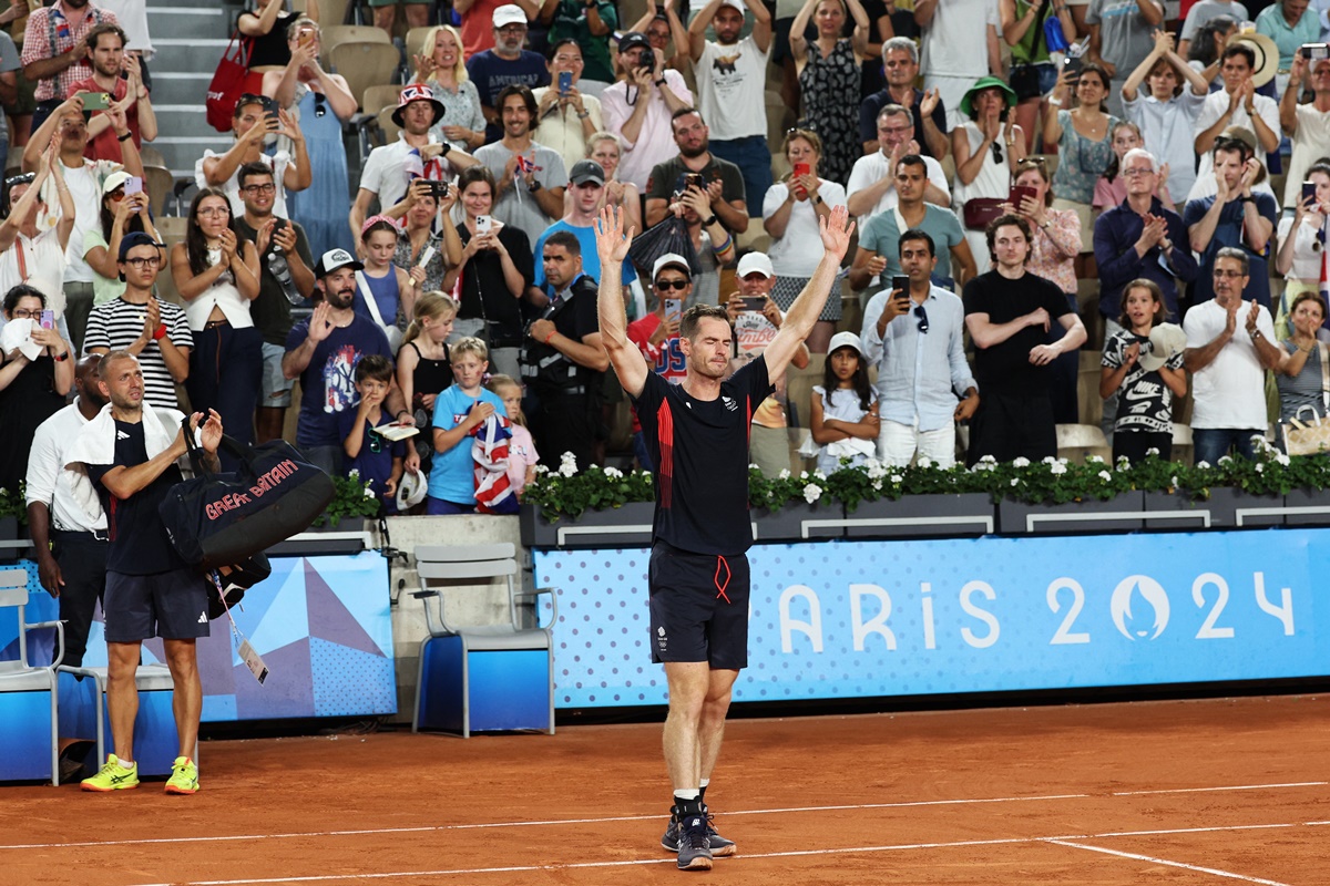 Andy Murray waves to the crowd as he walks off the court.