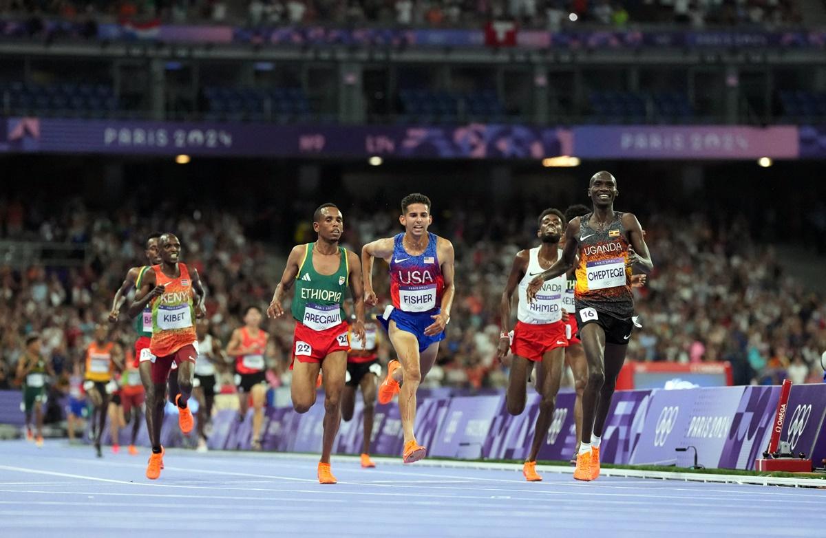 Joshua Cheptegei is all smiles as he crosses the finish line first.