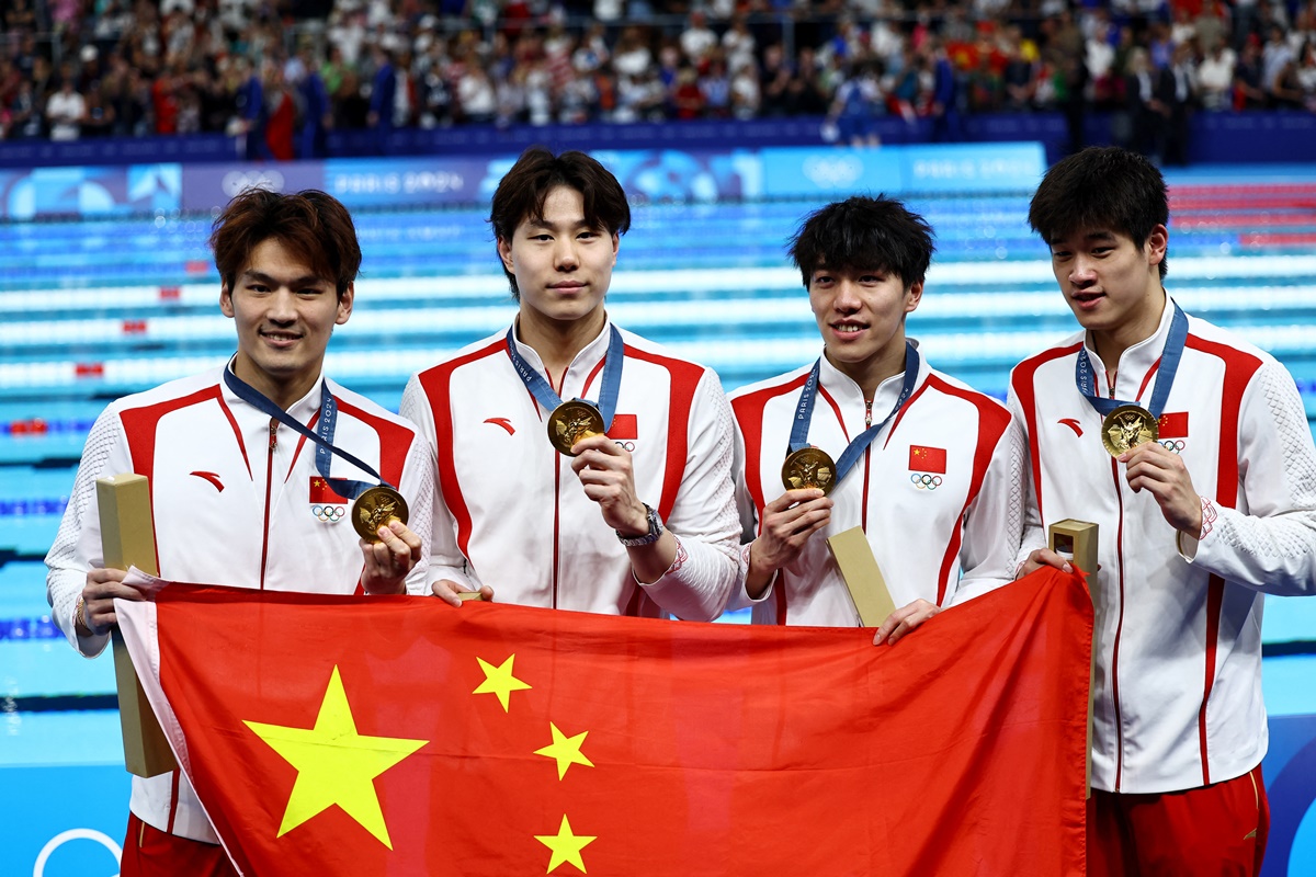 China's Jiayu Xu, Haiyang Qin, Jiajun Sun and Zhanle Pan pose with their gold medals and the Chinese flag after winning the Olympics swimming men's 4x100m Medley Relay at Paris La Defense Arena, Nanterre, France, on Sunday.