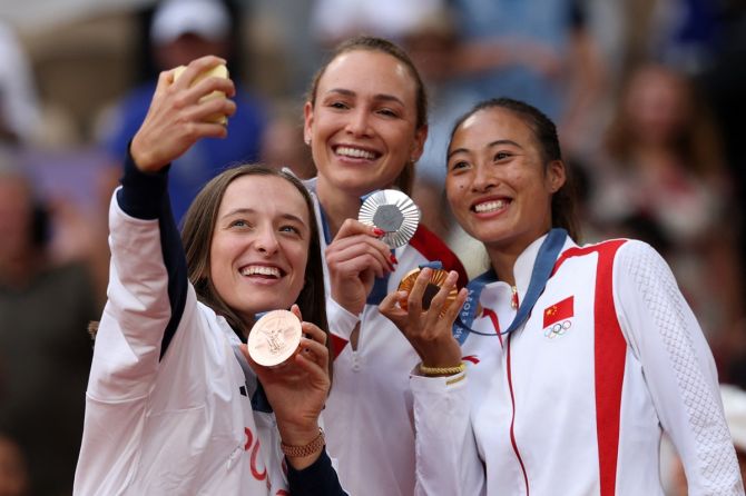 Qinwen Zheng, Donna Vekic and Iga Swiatek pose for a selfie with their medals.