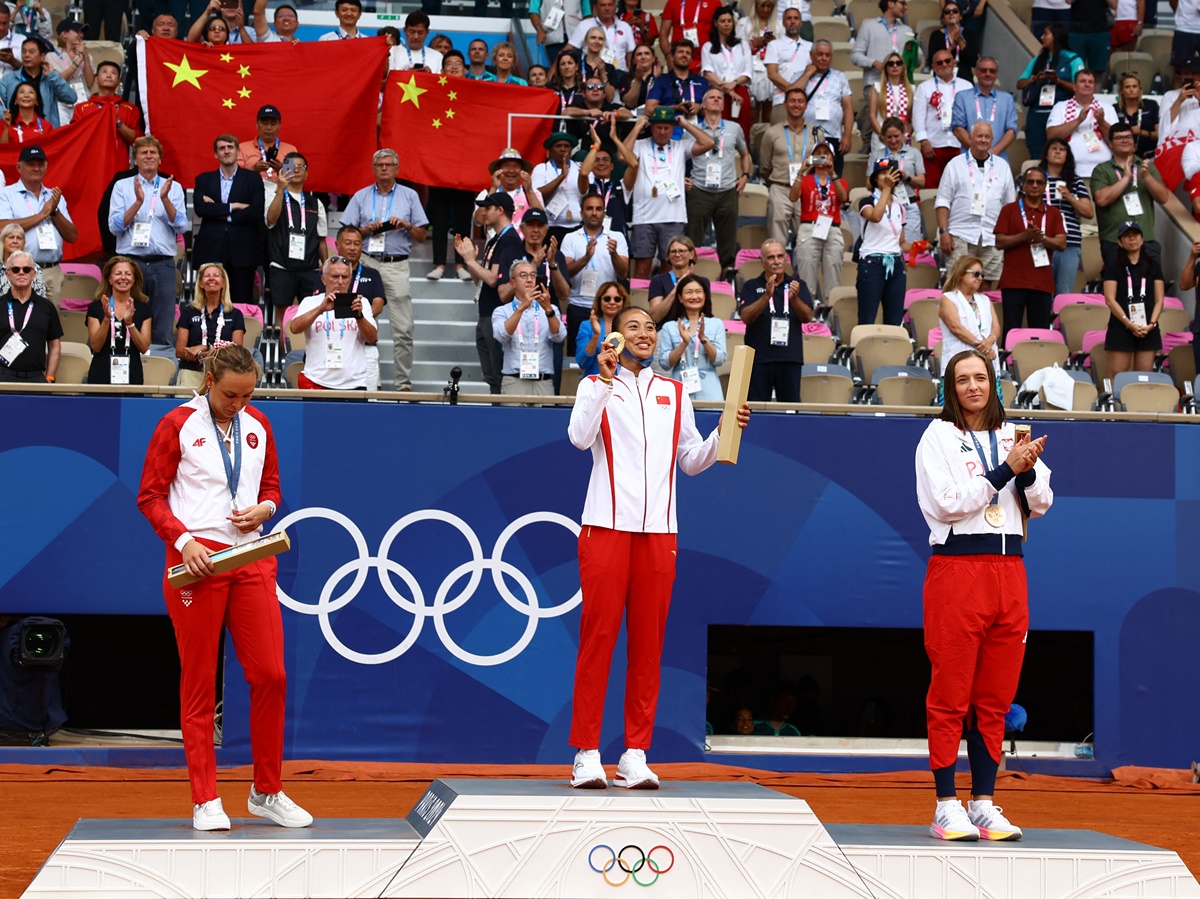 Gold medallist Qinwen Zheng of China on the podium with silver medallist Donna Vekic of Croatia and bronze medallist Iga Swiatek of Poland.