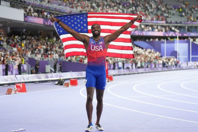 Noah Lyles of United States celebrates with his national flag after winning gold in the Olympics men's 100m final by a whisker at Stade de France, Saint-Denis, Paris, on Sunday.