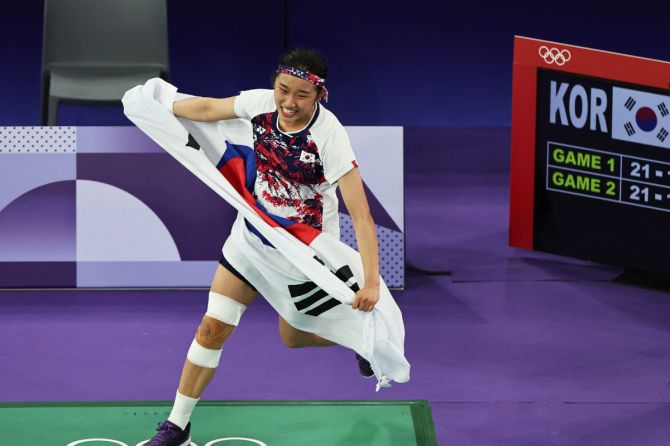 Se Young An of South Korea celebrates while holding the South Korean flag after beating Bing Jiao He of China to win the badminton women's singles gold medal at Porte de La Chapelle Arena, Paris, France, on Monday