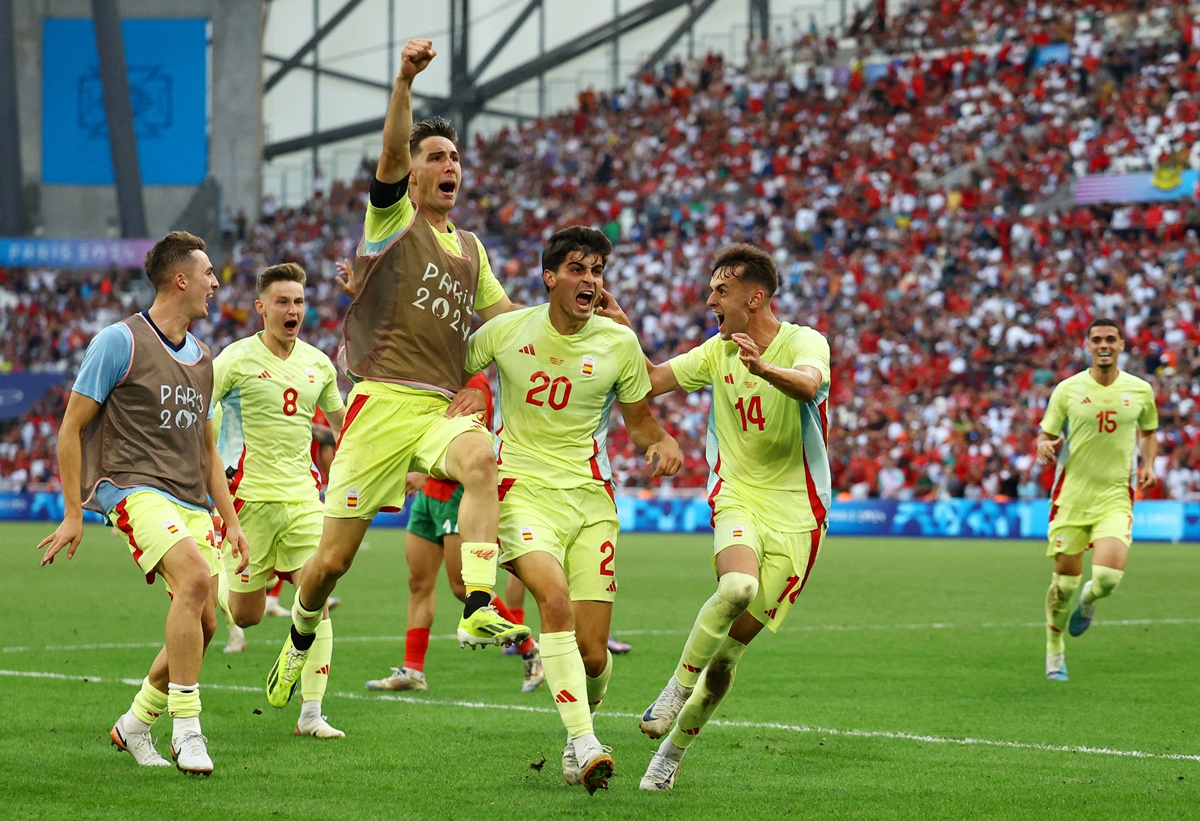 Juanlu Sanchez celebrates scoring Spain's second goal with teammates in the semi-final against Morocco at Marseille Stadium.