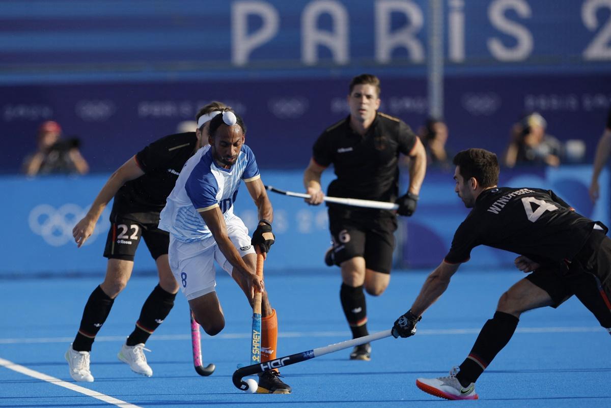 Hardik Singh tries to work his way past a host of German defenders.