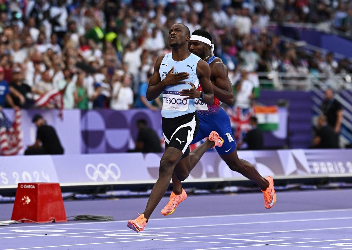 Letsile Tebogo celebrates as he slows down before crossing the finish line first.