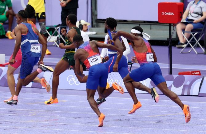 Christian Coleman virtually collides with Kenny Bednarek while making the first baton handover for the United States.