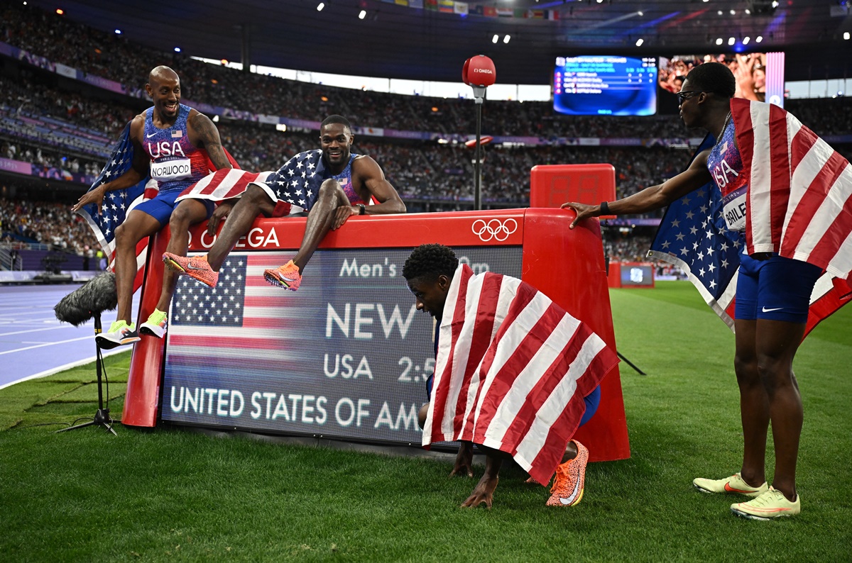 Bryce Deadmon, Rai Benjamin, Vernon Norwood and Christopher Bailey celebrate with their national flags after winning with a new Olympic record. 