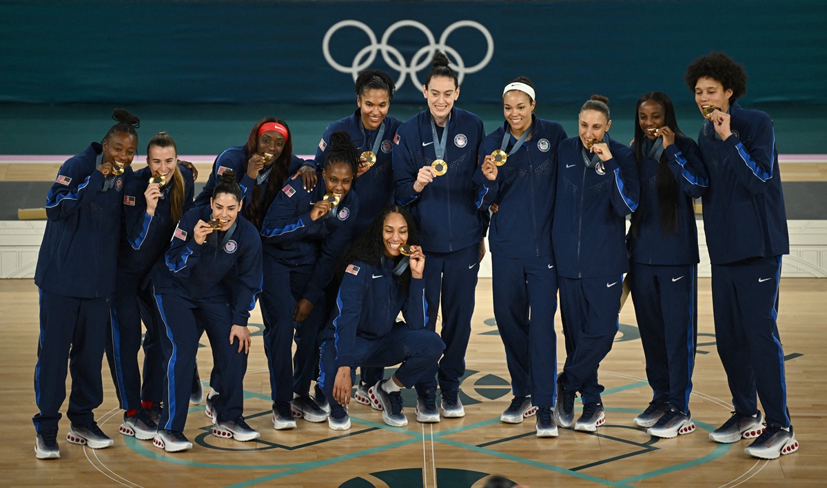 The United States women's basketball team pose with their medals after beating France in the gold medal match at Bercy Arena, Paris, on Sunday.