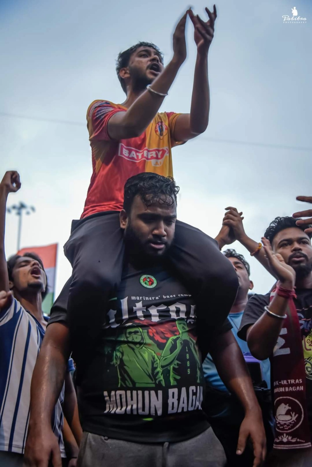 An East Bengal fan is seated on the shoulders of his Mohun Bagan counterpart during the protest on Sunday