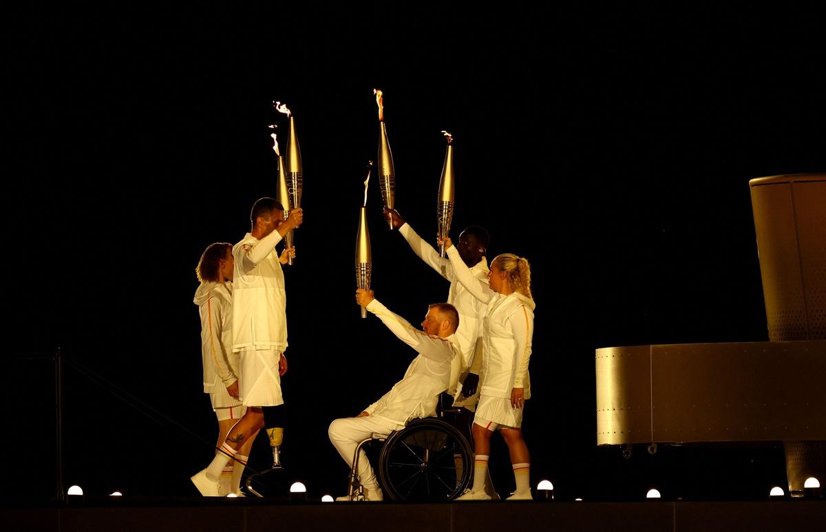 Charles-Antoine Kouakou, Nantenin Keita, Fabien Lamirault, Alexis Hanquinquant and Elodie Lorandi hold up their torches during the opening ceremony.