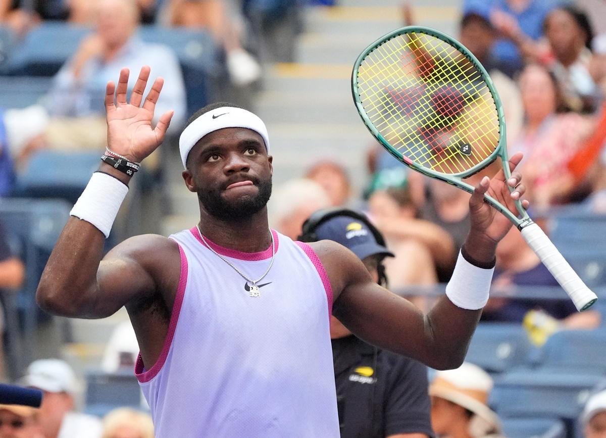 Frances Tiafoe of the United States waves to the crowd in muted celebration after Kazakhstan's Alexander Shevchenko retires following an injury.