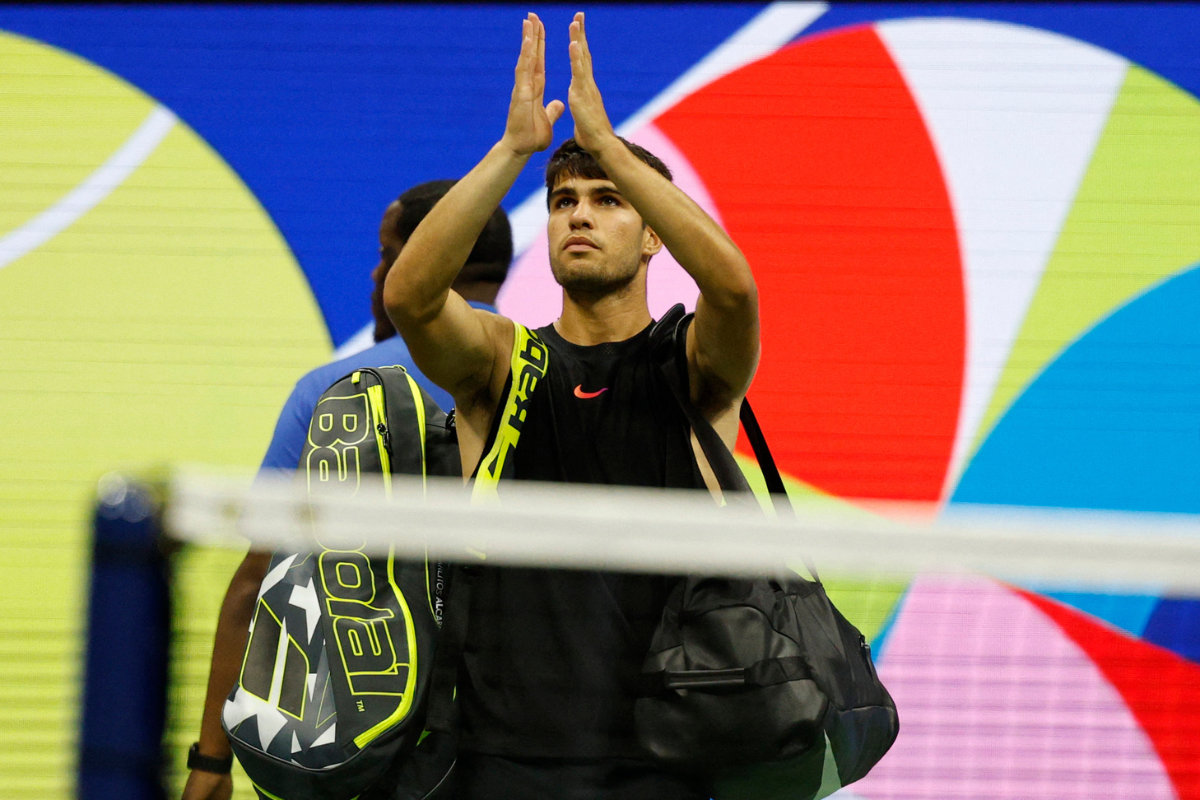 Carlos Alcaraz acknowledges the crowd while leaving the court after his match against Botic van De Zandschlup