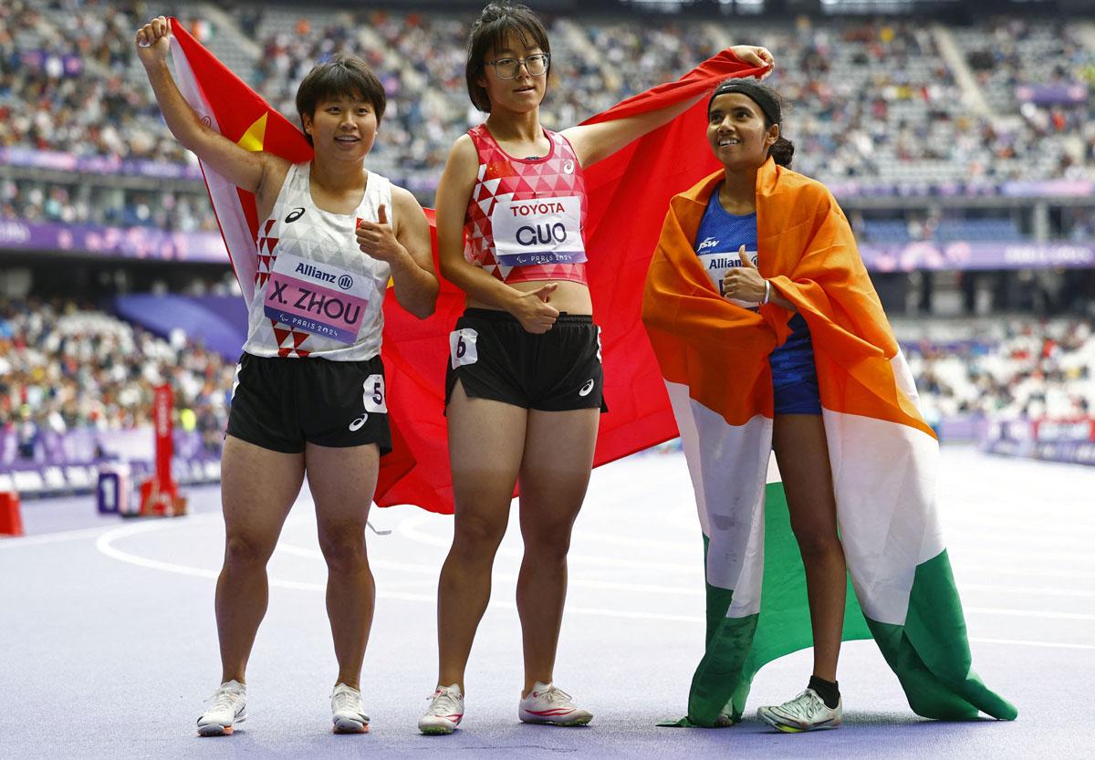 Bronze medallist Preethi Pal of India, right, with gold medallist Xia Zhou, centre, and silver medallist Qianqian Guo, both from China, after the Women's 100m - T35 Final