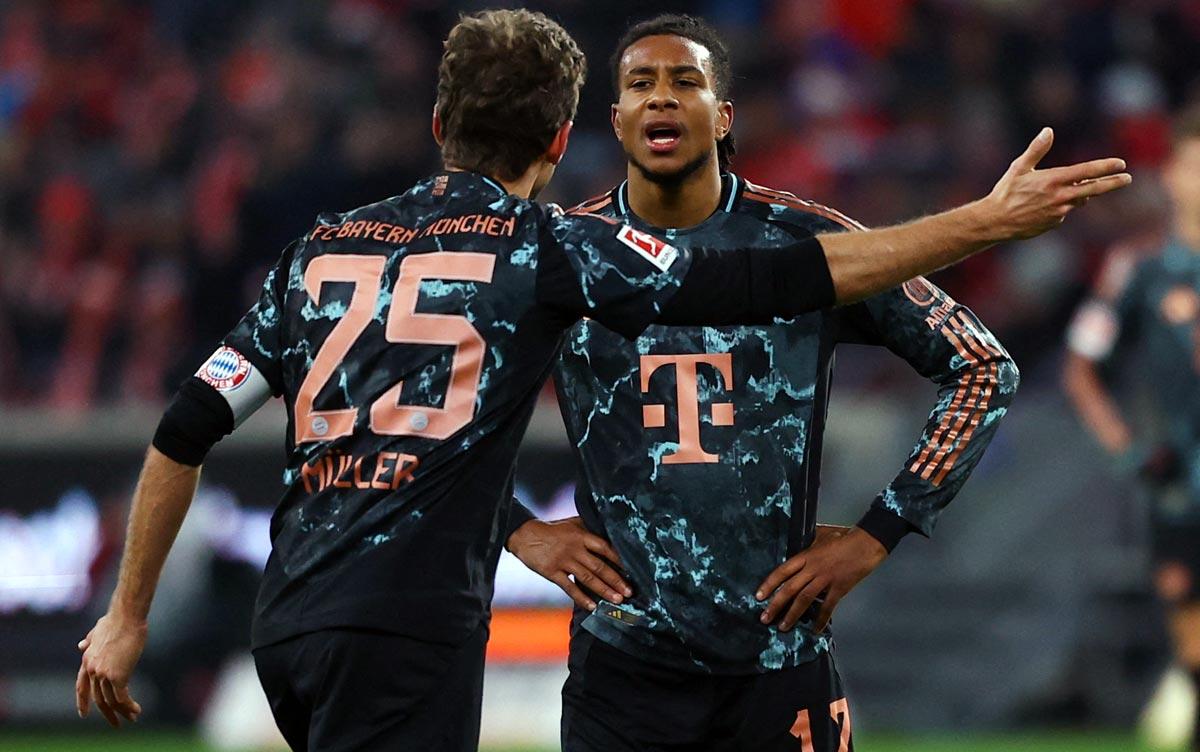 Bayern Munich's Thomas Mueller and Michael Olise argue