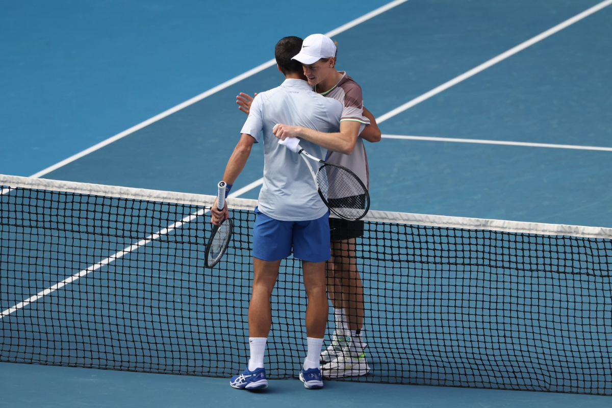 Jannik Sinner and Novak Djokovic embrace at the net after the match