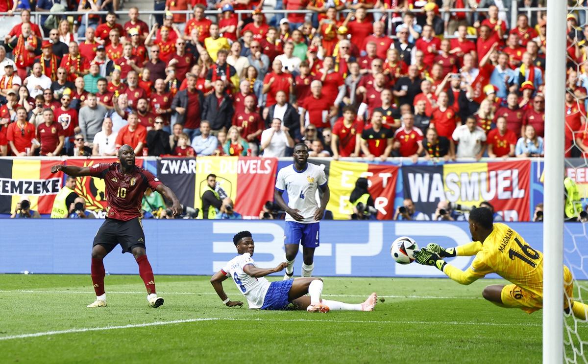 France's goalkeeper Mike Maignan makes a good save to deny Romelu Lukaku from close.