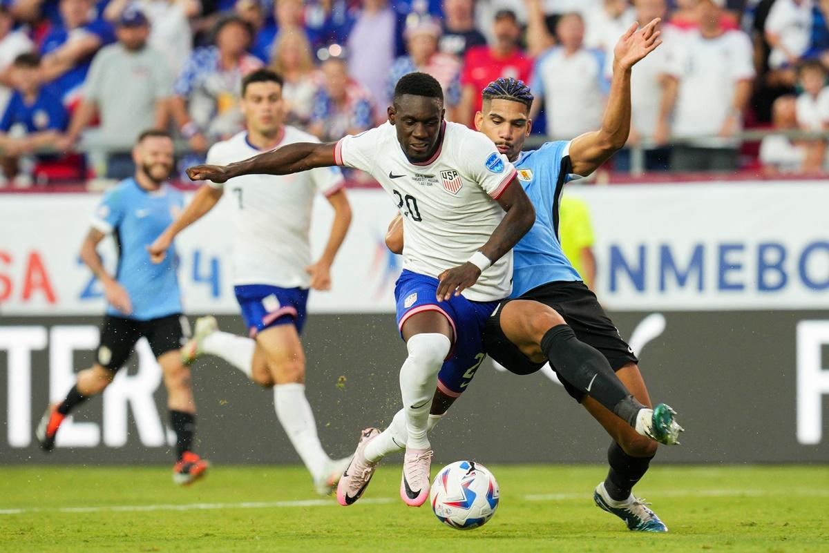 United States forward Folarin Balogun (No. 20) is tackled by Uruguay defender Ronald Araujo (4) during the Copa America match in Kansas City, Missouri, USA.