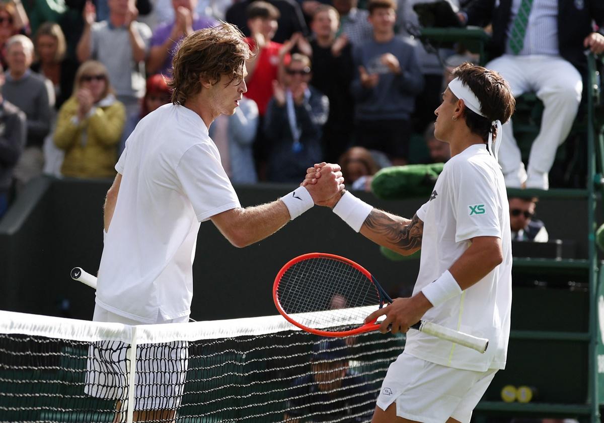 Francisco Comesana and Andrey Rublev meet at the net after their match.