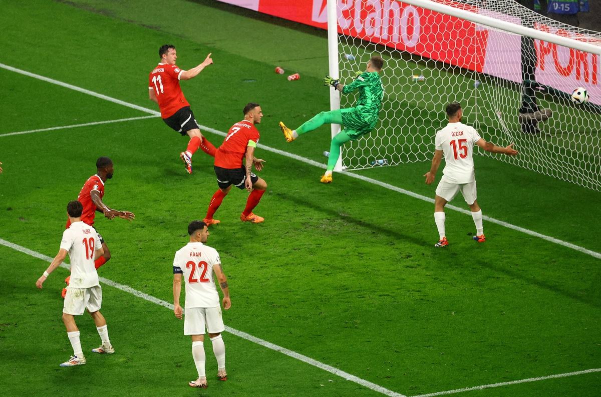 Michael Gregoritsch sends the ball past Turkey's goalkeeper Mert Gunok to pull Austria a goal back in the match.