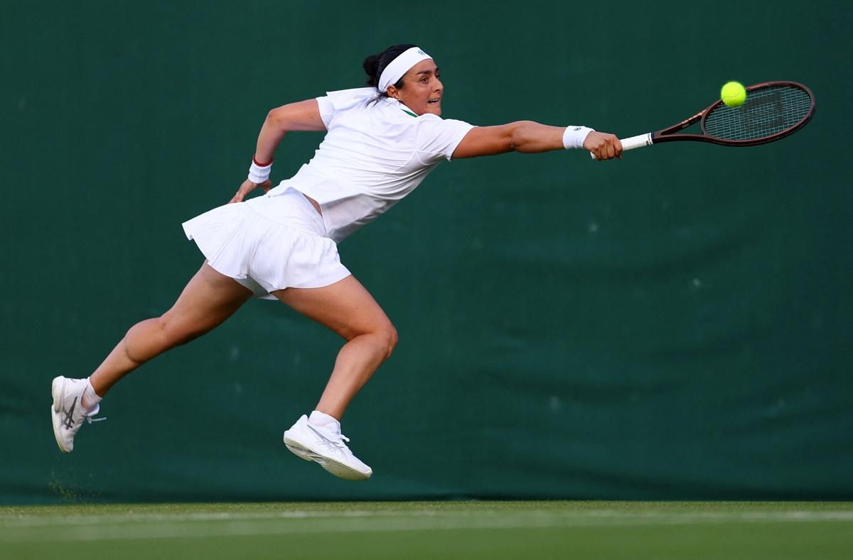 Tunisia's Ons Jabeur stretches to make a backhand return against Japan's Moyuka Uchijima.