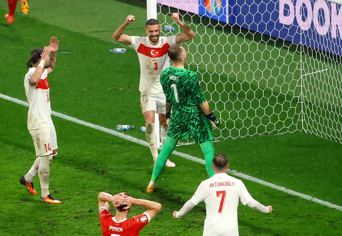 Turkey's goalkeeper Mert Gunok celebrates with Merih Demiral, Abdulkerim Bardakci and Kerem Akturkoglu after making a save from Austria's Christoph Baumgartner in stoppage time.