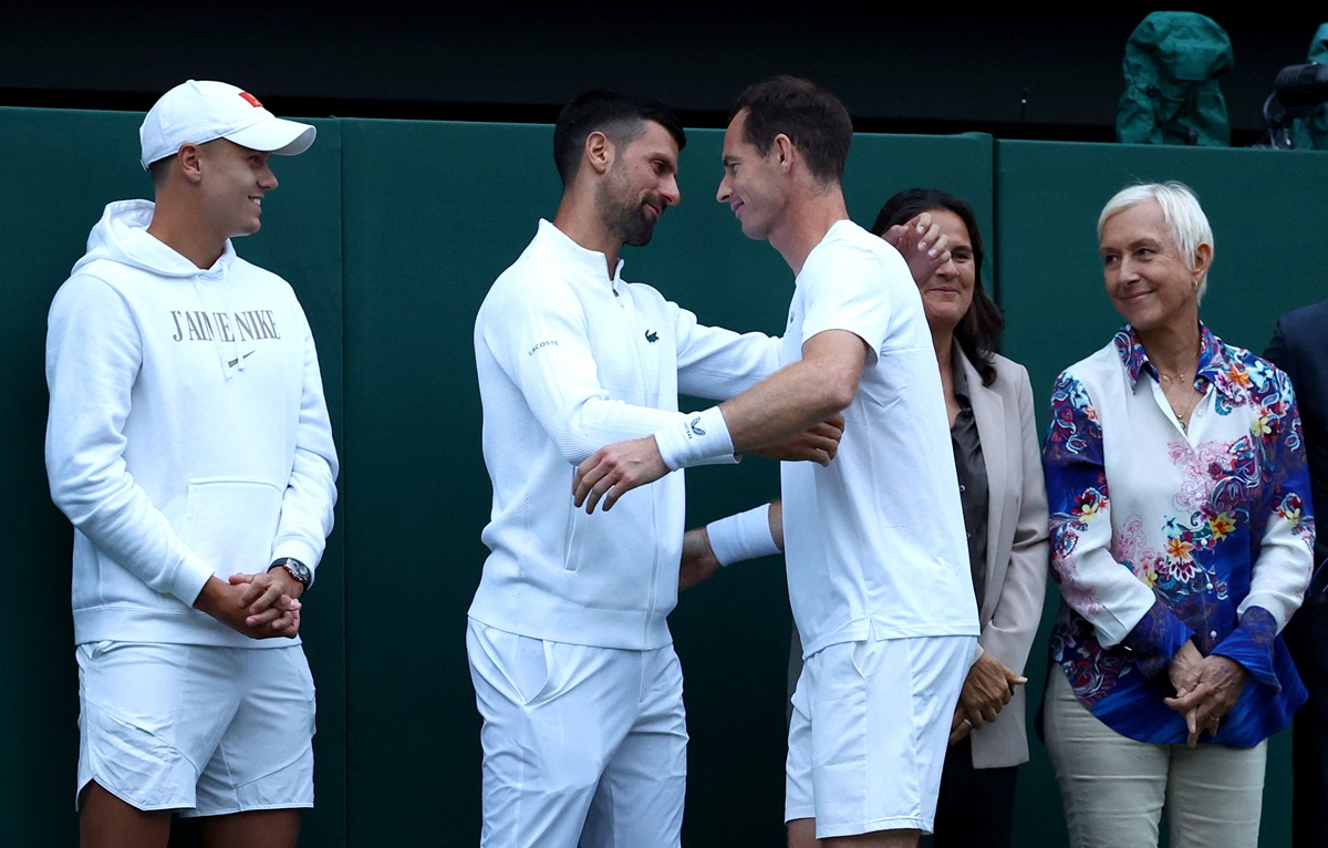 Andy Murray gets a hug from Novak Djokovic as Holger Rune, Conchita Martinez and Martina Navratilova look on.