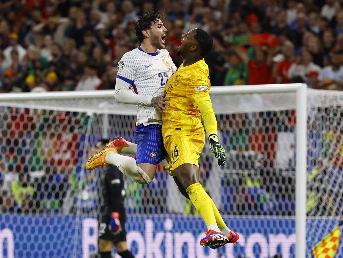 Theo Hernandez celebrates with goalkeeper Mike Maignan after winning the penalty shoot-out for France in the Euro 2024 quarter-final against Portugal, at Hamburg Volksparkstadion, Germany, on Friday.