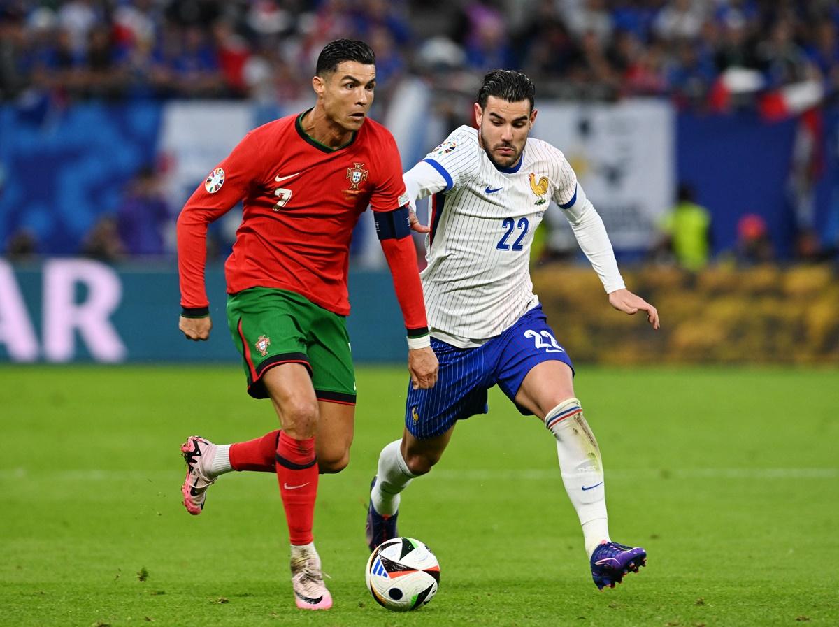 France defender Theo Hernandez in hot pursiut of Cristiano Ronaldo as he breaks into the box.