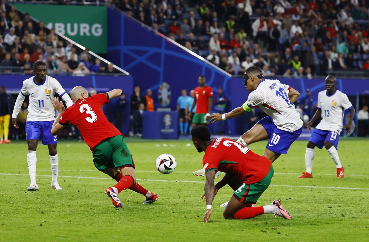 Kylian Mbappe drills a shot at the Portugal goal.