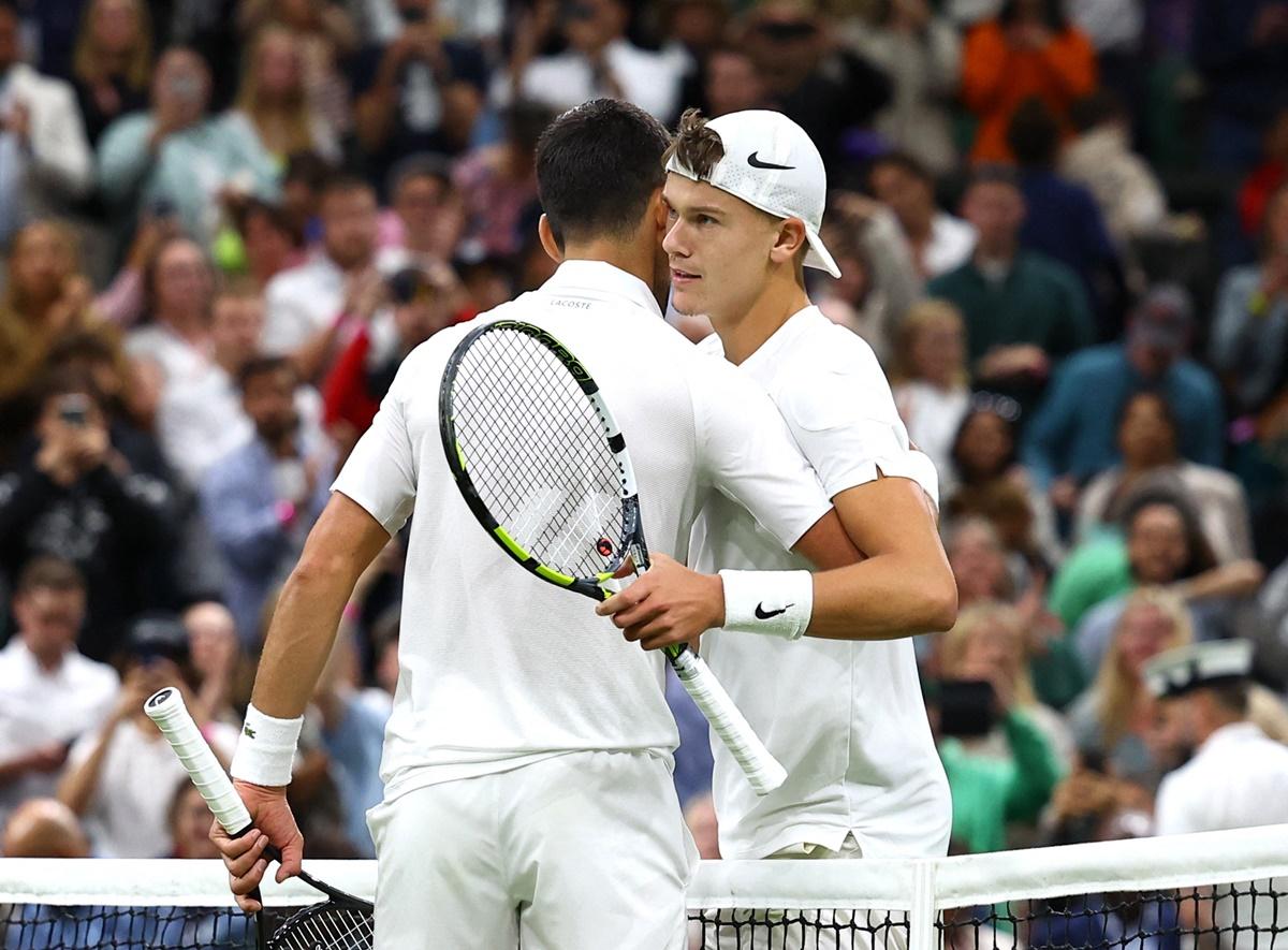 Novak Djokovic hugs Holger Rune at the net after the match.