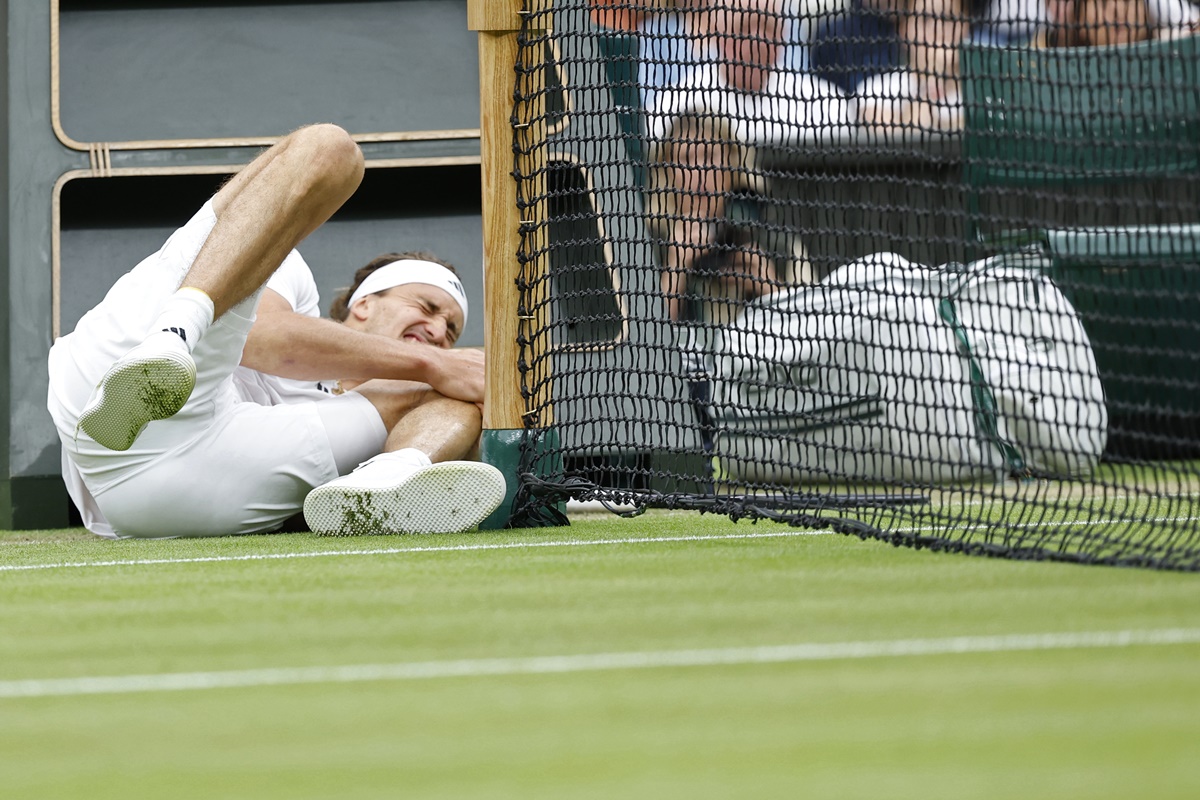 Germany's Alexander Zverev holds his knee after taking a fall chasing a shot from Britain's Cameron Norrie in the men's singles fourth round match at the Wimbledon Championships on Monday.