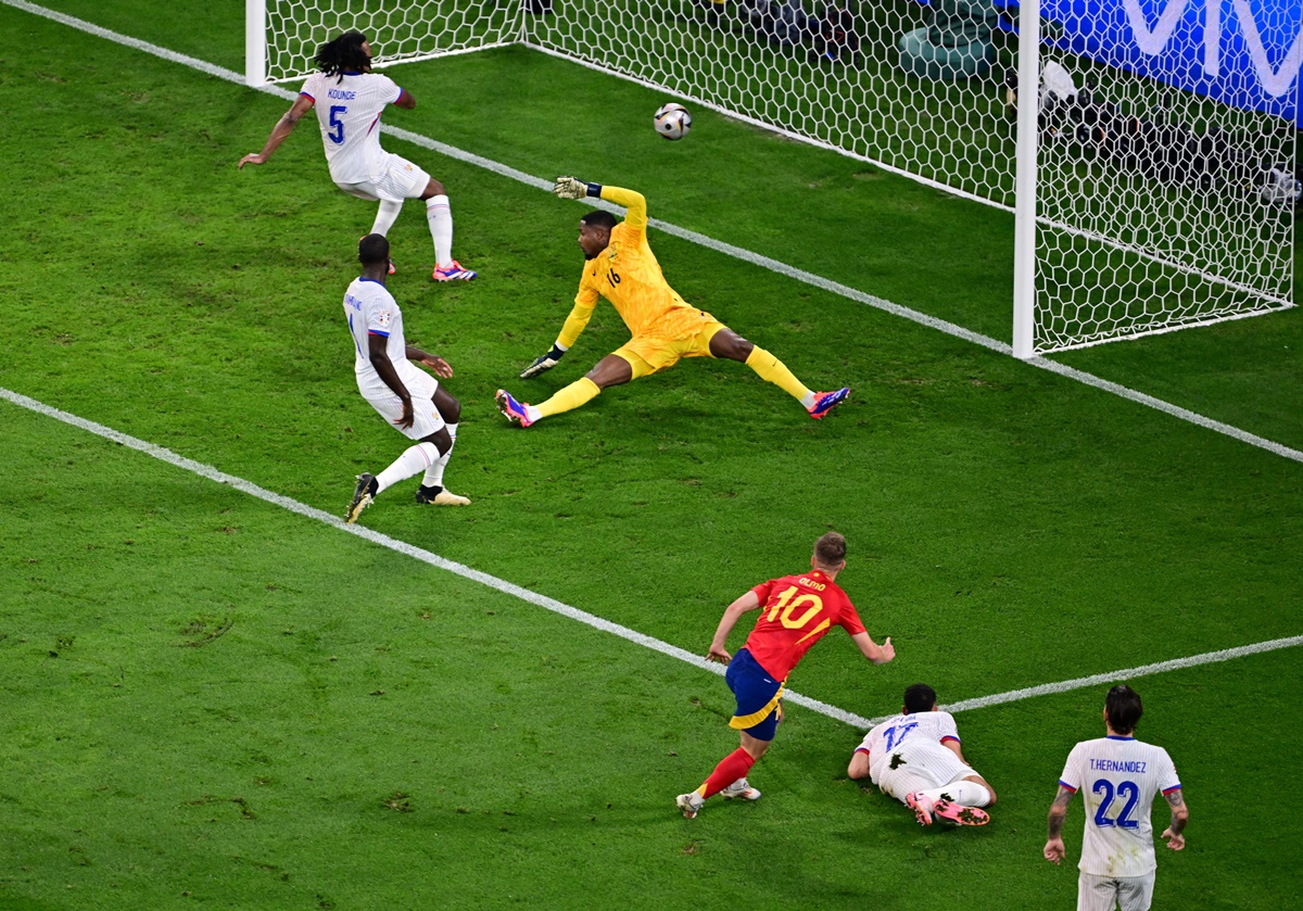 France defender Jules Kounde (No. 5) deflects a goalbound shot from Spain striker Dani Olmo (No. 10) into his own goal.