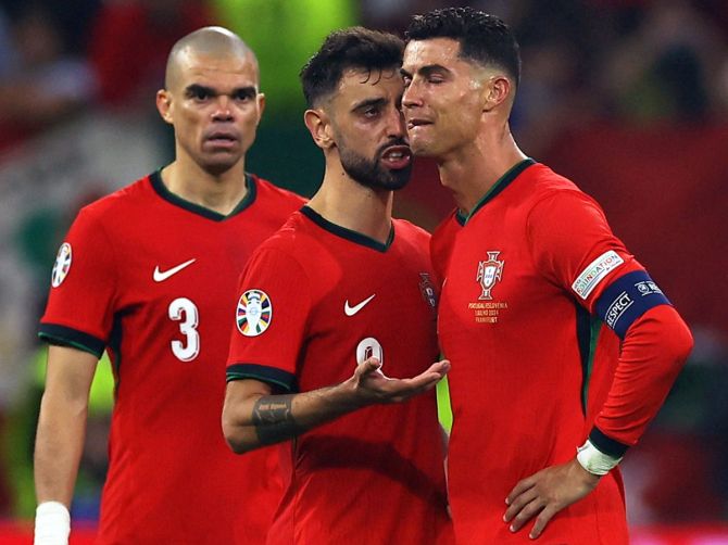 Bruno Fernandes consoles Cristiano Ronaldo as he walks off the filed after regulation time.