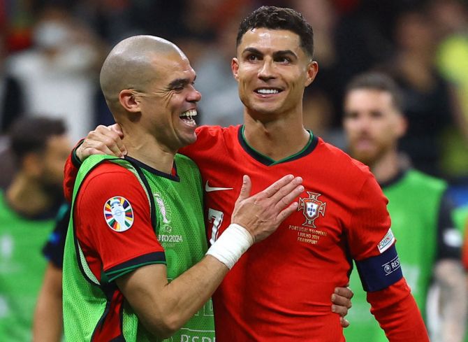 Cristiano Ronaldo celebrates with team-mates Pepe after winning the match against Slovakia.