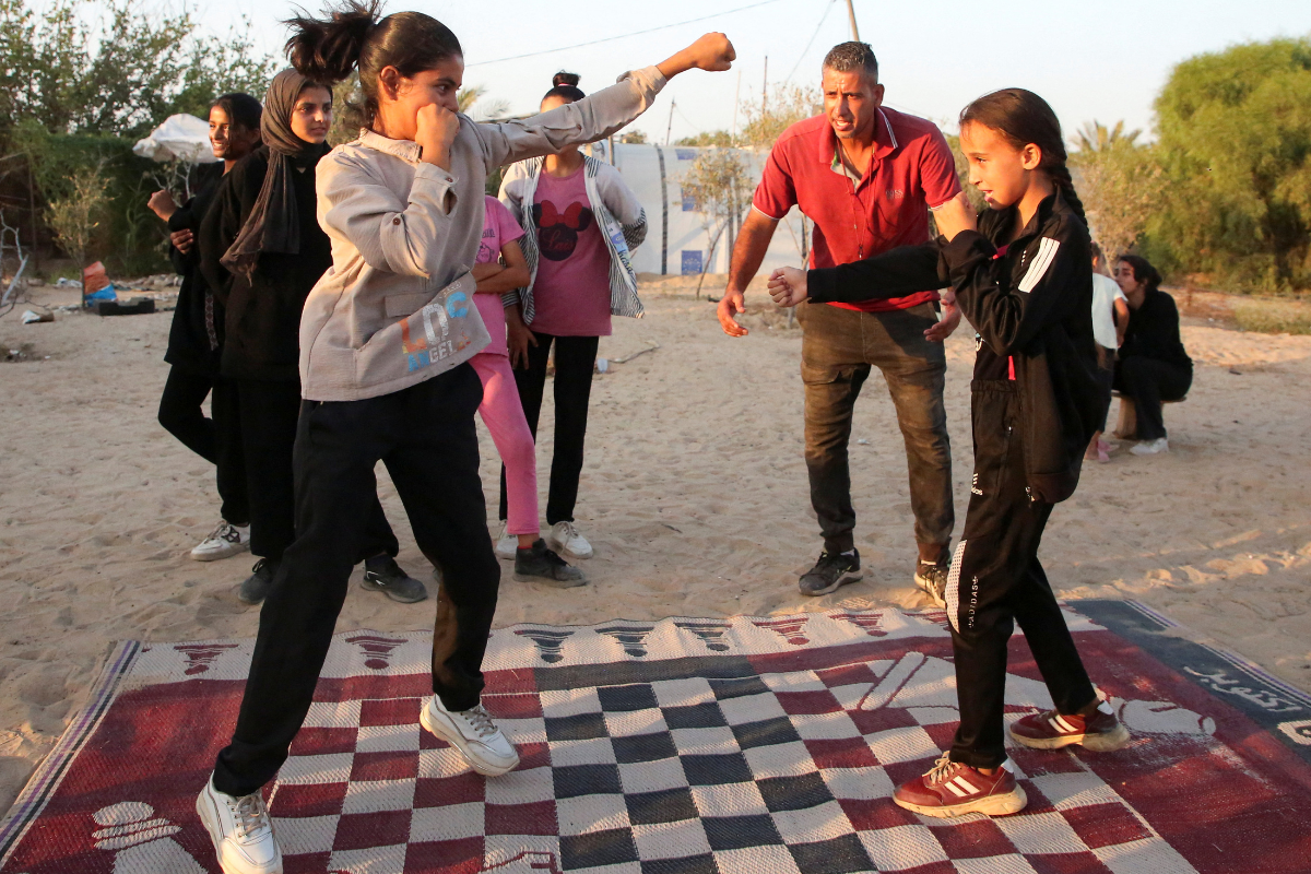 Palestinian boxing coach Osama Ayoub trains girls near a tent camp sheltering displaced people, amid Israel-Hamas conflict, in Khan Younis in the southern Gaza Strip on July 10, 2024.