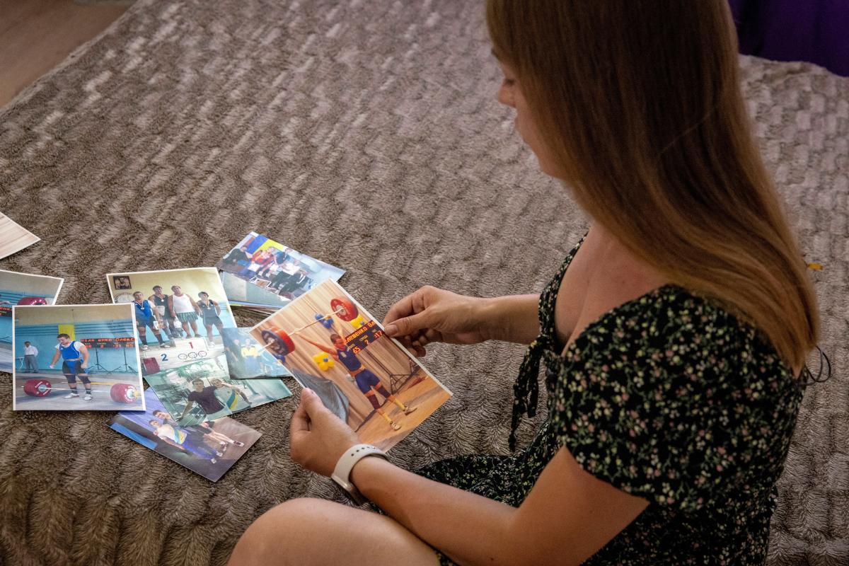 Fiana Pielieshenko looks at pictures of her late husband, Olympic weightlifter Oleksandr Pielieshenko, who was killed fighting against Russia's invasion, in their apartment in Kyiv, amid Russia’s attack on Ukraine