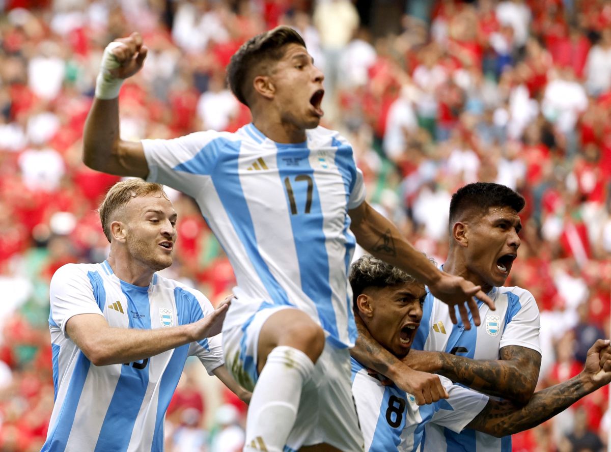 Argentina's Cristian Medina celebrates with teammates after finding the net in the dying seconds of the Olympics men's Group B football match against Morocco, at Geoffroy-Guichard Stadium, Saint-Etienne, France, on Wednesday. 